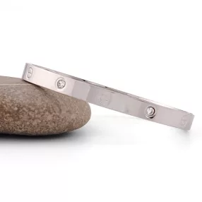 Ezüstszínű nemesacél karperec fehér kristályokkal